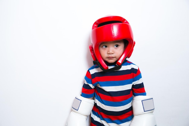 Garçon mignon asiatique avec des gants de boxe blancs et un garde-chef rouge sur fond blanc