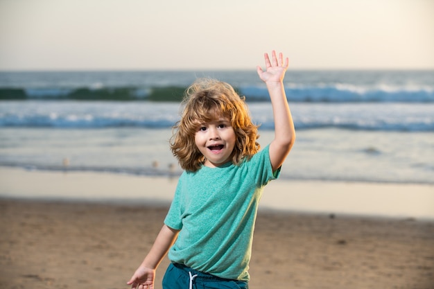 Garçon mignon drôle d'enfant marchant la plage de mer