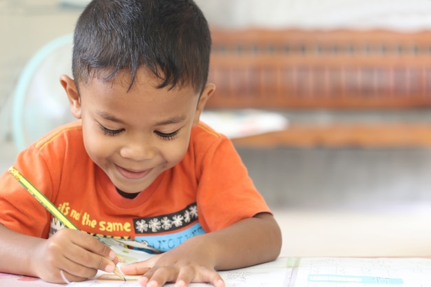 Garçon Mignon D'enfant étudiant Et Pensant à La Maison.