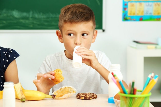 Garçon mignon à l'heure du déjeuner en classe