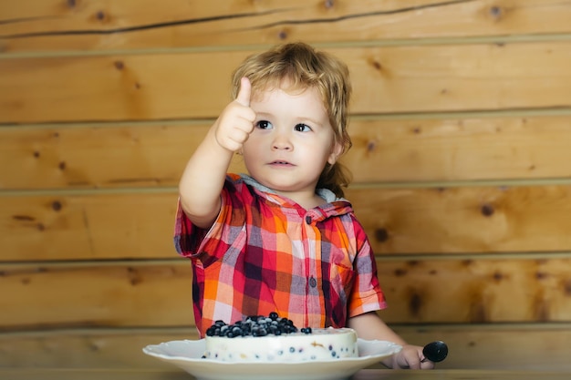 Le garçon mignon mange le gâteau