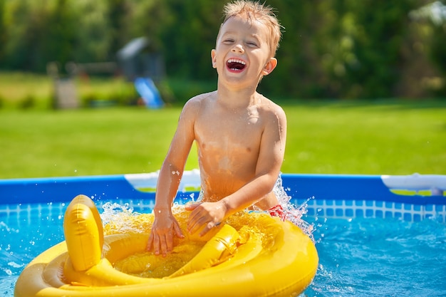 Garçon mignon nageant et jouant dans une piscine d'arrière-cour