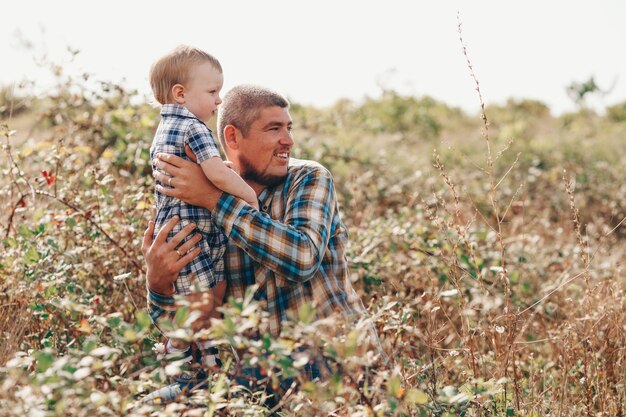 Garçon mignon avec papa joue en plein air