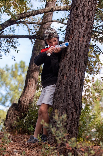 Garçon mignon avec pistolet à eau