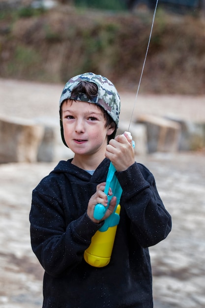 Garçon mignon avec pistolet à eau