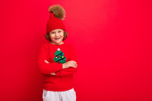 Garçon mignon avec un pull de Noël et un chapeau