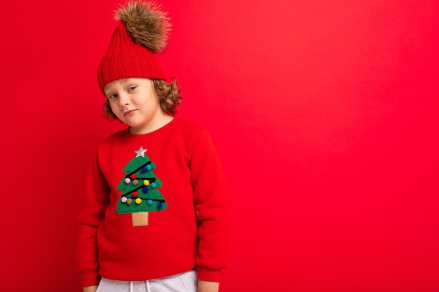 Garçon mignon avec un pull de Noël et un chapeau