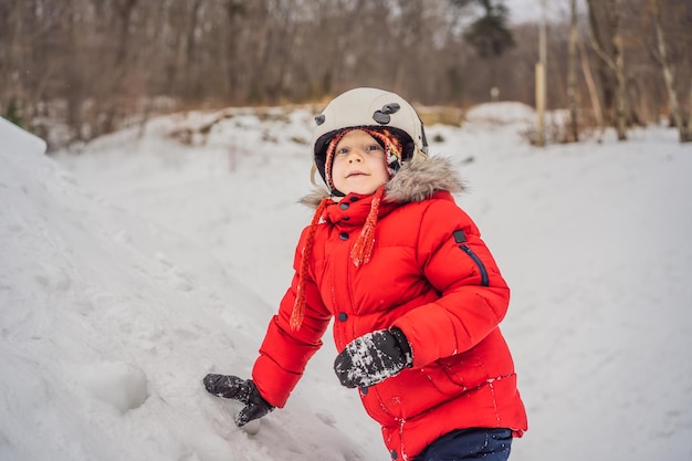 Le garçon mignon s'élève sur une montagne neigeuse