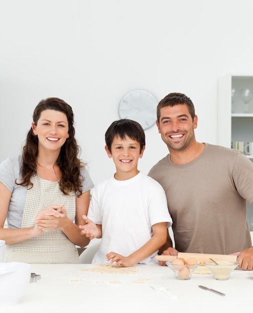 Garçon mignon avec ses parents dans sa cuisine