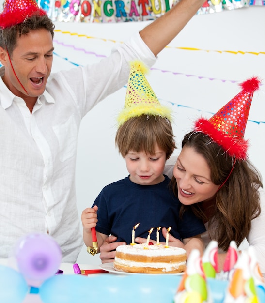 Garçon mignon soufflant les bougies sur son gâteau d&#39;anniversaire