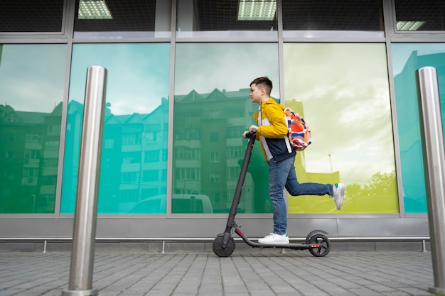 Garçon monte sur un scooter électrique
