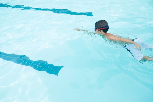 Garçon nageant dans la piscine au centre de loisirs