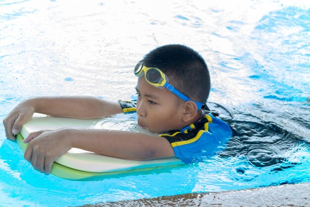 Photo un garçon nageant dans la piscine.