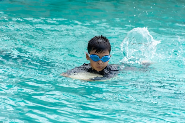 Un garçon nageant dans la piscine.