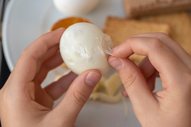 Le garçon nettoie l'œuf avec ses mains