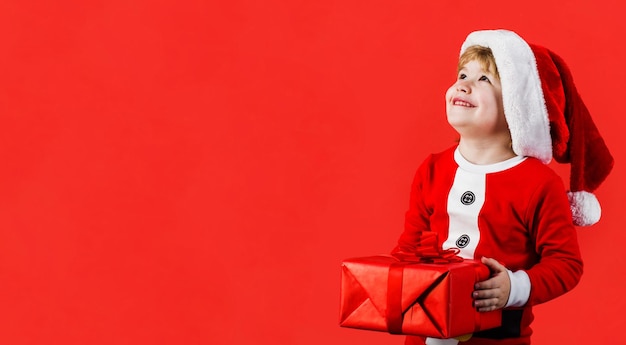 Garçon de noël petit enfant avec cadeau de nouvel an santa kid avec boîte-cadeau espace de copie d'hiver