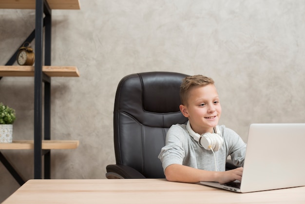 Photo garçon avec ordinateur portable au bureau