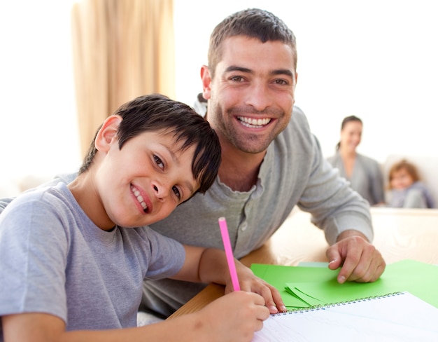 Garçon peignant avec son père à la maison