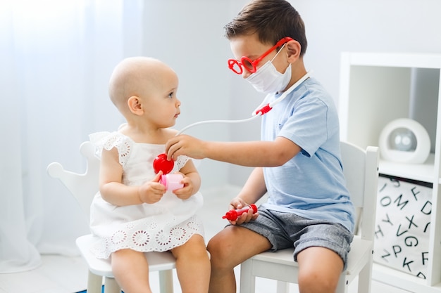 Photo garçon et petite fille jouant au médecin et au patient