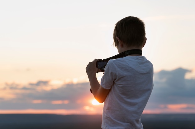 Garçon photographie le coucher du soleil