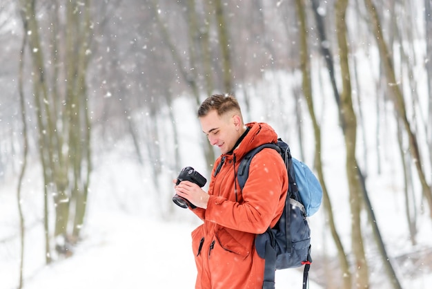 Garçon de photographie regardant la photo à l'appareil-photo tout en marchant dans la forêt