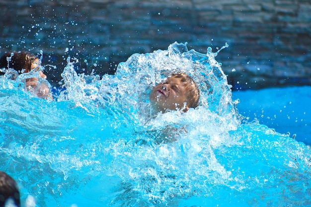 garçon sur un plan d'eau rester dans le parc aquatique en été