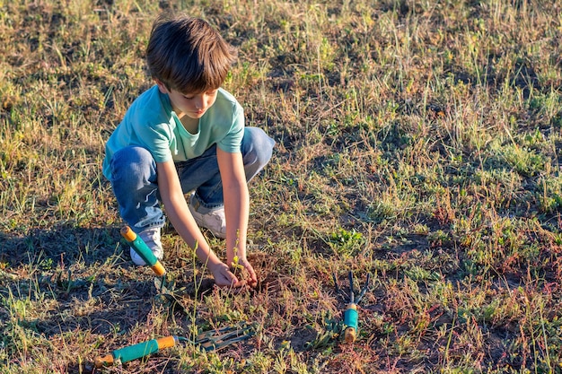 Garçon plantant un arbre dans une forêt Eco Concept Jour de la Terre Sauvez la planète