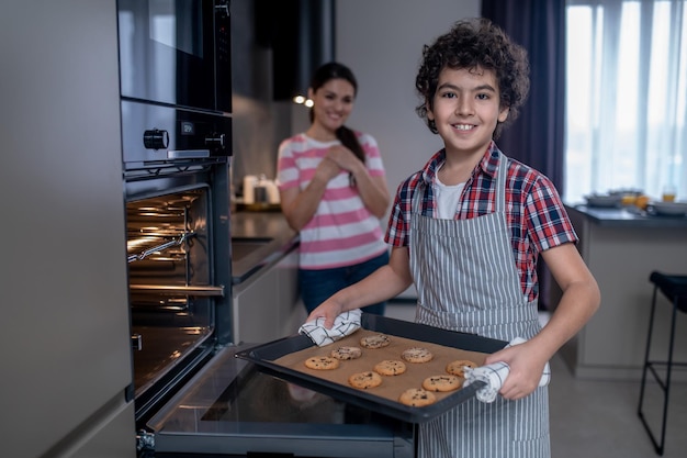 Garçon avec une plaque à biscuits en regardant la caméra