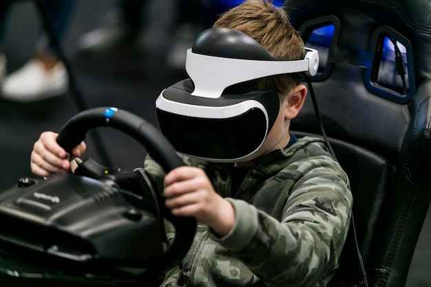 Un garçon portant un casque de réalité virtuelle joue à un jeu de course