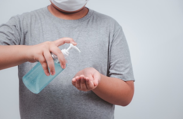Garçon portant un masque et se laver les mains avec un désinfectant antibactérien.