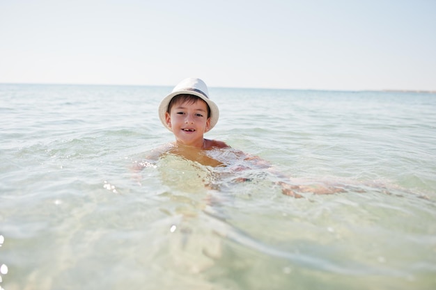 Garçon porter un chapeau panama nager dans la mer Rouge