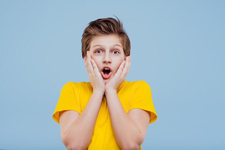 Photo garçon préadolescent choqué en t-shirt jaune isolé sur mur bleu, espace copie