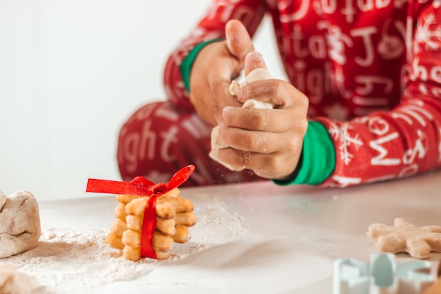 Garçon préparant des biscuits pour Noël à la maison, gros plan