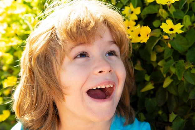 Garçon de printemps dans un arbre en fleurs dans le parc du printemps Enfant souriant en plein air Jardin de fleurs