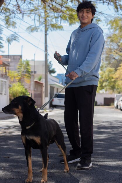 Un garçon promène son chien dans le quartier