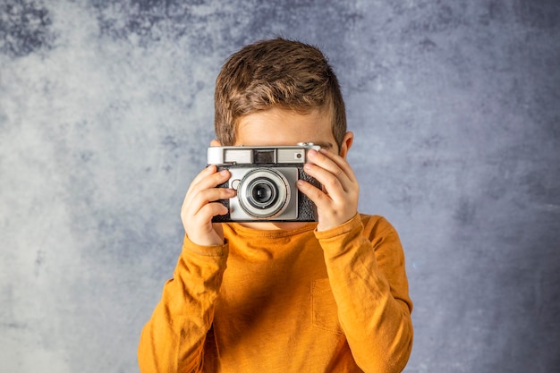 Un garçon qui prend des photos contre le mur.