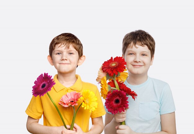 Garçon qui rit avec des fleurs de gerbera bouquet.