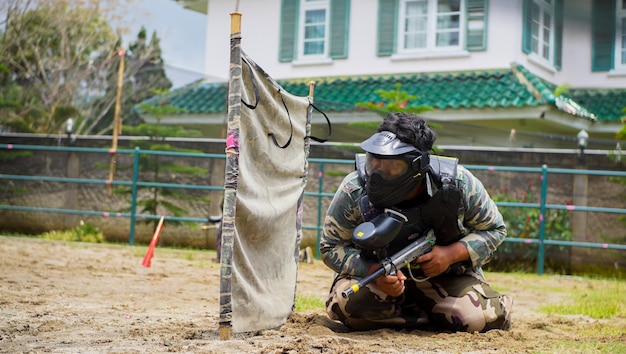 un garçon qui sonde son ennemi en jouant au paintball