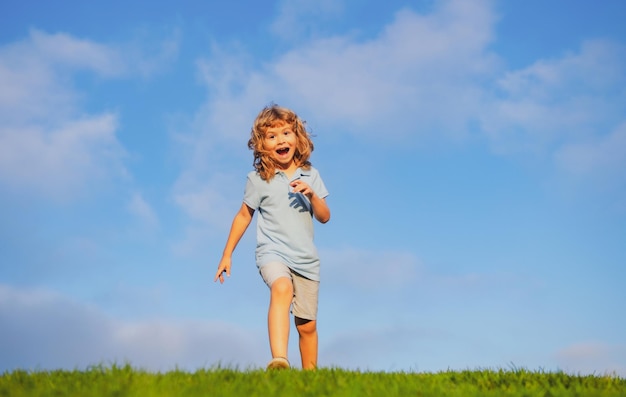 Garçon de race blanche dans un parc en cours d'exécution et souriant happy kid rire émotion visage joie enfant joyeux drôle s