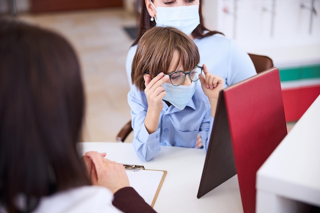 Garçon regardant dans le miroir avec ses nouvelles lunettes