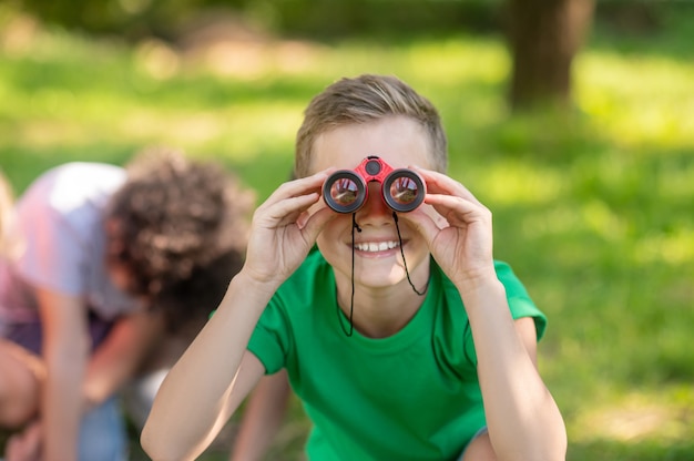 Garçon regardant à travers des jumelles dans la nature