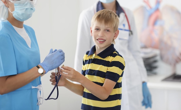 Le garçon a un rendez-vous à la clinique. Le pédiatre va examiner l'état de santé du garçon.