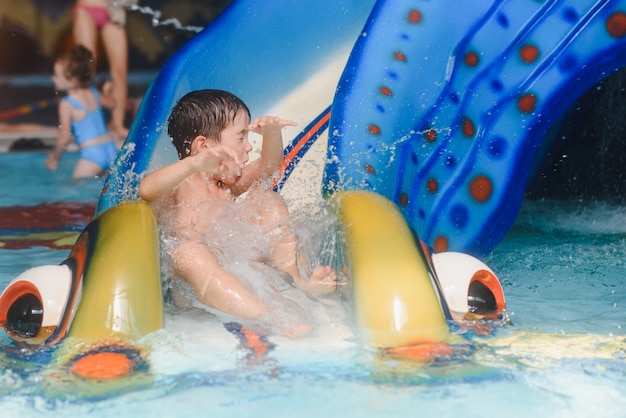 Le garçon roule avec un toboggan dans un parc aquatique de Little Rock