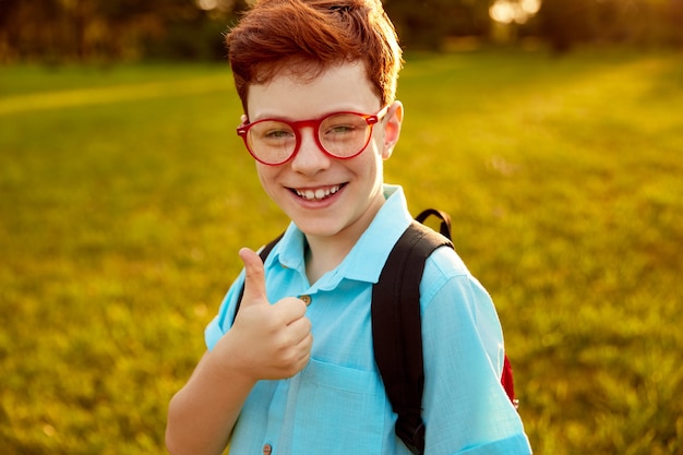 Garçon rousse souriant montrant le pouce vers le haut et regardant la caméra