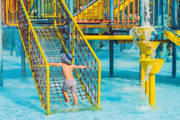 Photo le garçon s'amuse dans le parc aquatique