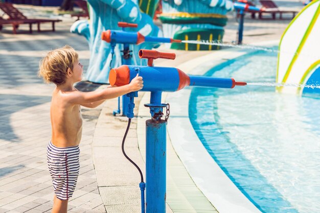 Le garçon s'amuse dans le parc aquatique