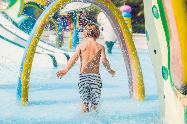 Le garçon s'amuse dans le parc aquatique