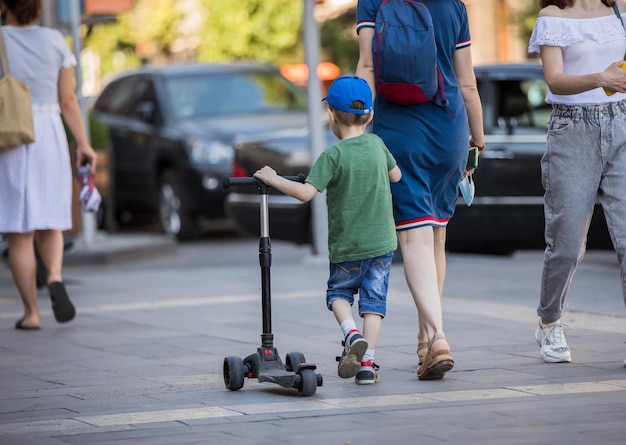 Garçon sur un scooter roulant dans la ruexA