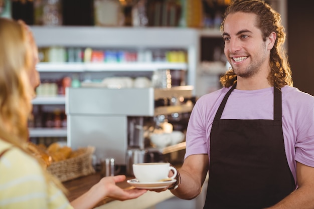 Garçon servant une tasse de café au comptoir