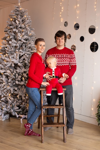 Garçon et ses parents près d'un arbre de Noël. Notion de Noël. Nouvelle année.